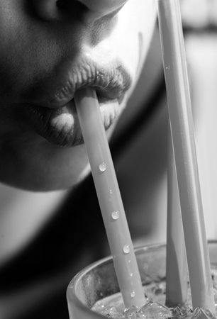 Closeup girl drinking a cocktail. Woman lips.の写真素材