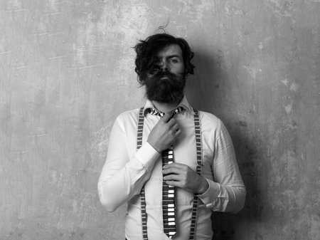 Crazy man with suspenders feel candid face expression. Portrait of funny bearded man in white shirt...
