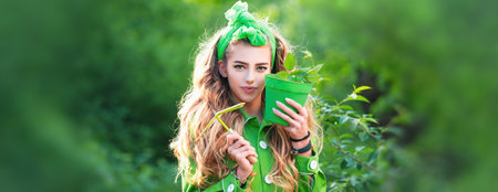Spring design with beautiful woman face for banner or website header, copy space. Happy female gardener with spring flowers in pot. Beauty spring girl with flower pot. Planting flowers.の写真素材