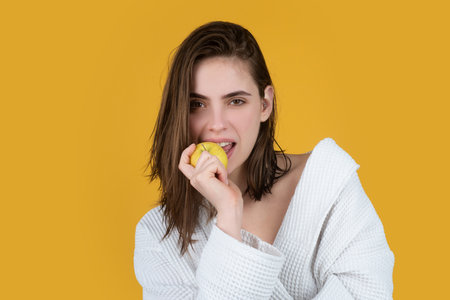 Woman with apples. Portrait of young beautiful sexy girl with apple. Vegetarian woman isolated on yellow studio background. Healthcare and dental care concept. Healthy diet fruits. Girl eat apple.の写真素材