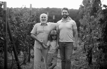 Boy child with father and old grandfather in garden. Farmer men farming and gardening on farm oncountryside.の写真素材