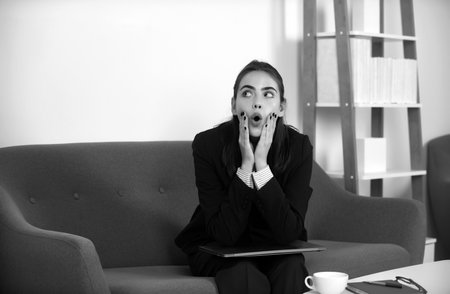 Surprised funny business woman entrepreneur working in office, professional employee at workplace. Young beautiful secretary girl. Business emotions.の写真素材