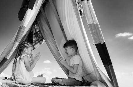Happy children. Brother and sister relationships. Affection and care. Children family playing in tent. Cute kids having fun outdoors.の写真素材