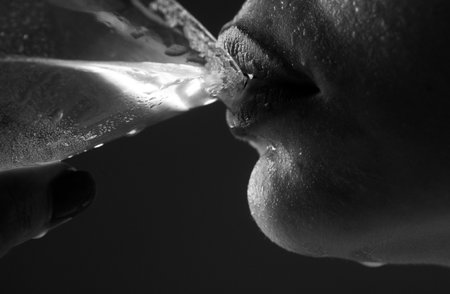 Woman drink cocktail. Close up wet sexy lips. Young girl drinking red lip cocktail closeup.