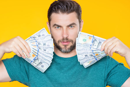 Successful business man counting money. Handsome middle age man holding bunch of 100 dollar banknotes. Guy holding money cash. Profit and financial success. Rich man with dollar cash.の写真素材