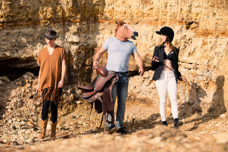 Crazy strange people with horse mask. Freaky young horsewoman women and crazy comic man with horse mask. Funny horse head. Comical Funny people. Absurd and funny friends. Fake and humor.の写真素材