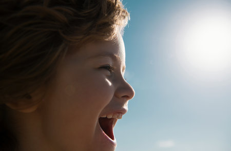 Portrait of a happy laughing child. Close up positive kid screaming, profile face.の写真素材
