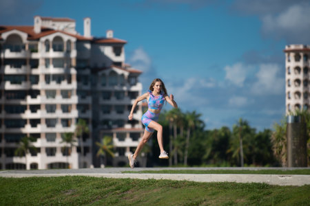 Running woman jogging on South beach, Miami, Florida. Fit woman doing workout on Miami beach. Summer...