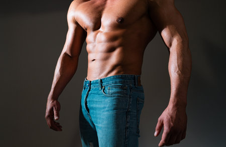 Bare torso of muscular man. Muscular man showing his chest during striptease. Mans torso. Handsome guy posing. Fashion portrait of sporty healthy strong muscle guy. Sexy torso. Shirtless male model.の写真素材