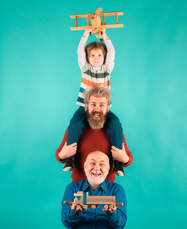 Fathers day. Kid having fun with toy plane. Men generation family with three different generations ages grandfather father and son. Family adventure, imagination and innovation inspiration concept.の写真素材