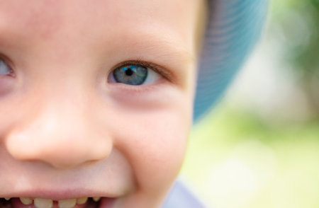 Spring kids portrait. Closeup face of cute smiling child with blue eyes. Kid emotions concept. Portrait of young laughing boy outdoor.の写真素材