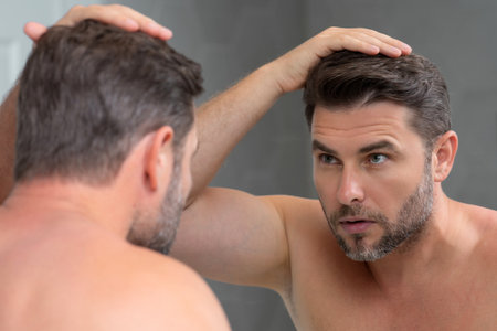 Male beauty. Cream treatment for male face. Beauty routine. Face of a beautiful man with perfect skin. Anti-aging and wrinkle cream. Concept of male beauty. Male skincare cosmetics concept. Skin care.の写真素材