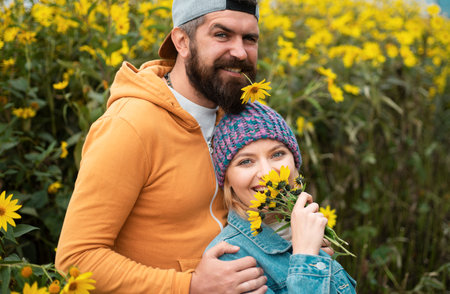 Young lovers hugging and embracing in autumn park with flovers. Couple in love tenderness and affection.の写真素材