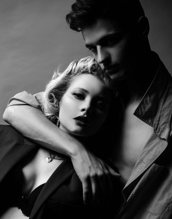 Handsome guy is hugging pretty girl with blonde hair. I Love You. Passion sex. Husband and wife get sexual pleasure from hugging. Muscular man. Pose for family portrait.の写真素材