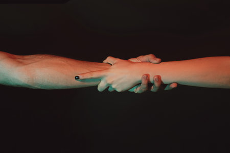 Holding hand, close up. Giving a helping hand. Rescue, helping gesture or hands. Salvation relations. Support hand. Helping hand gesture, sign of help and hope. Helping arm, charity.の写真素材