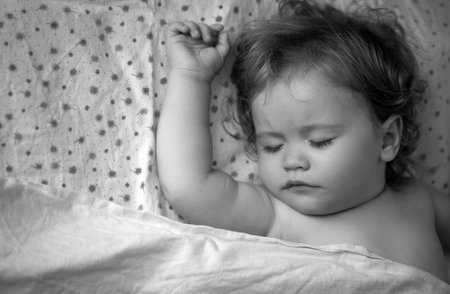Baby sleeping in the bed. Kids sleepy face, child sleep. Close up cuye kid face.の写真素材