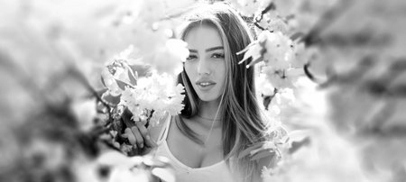 Beauty spring woman face. Happy beautiful young girl relaxing in blossom park. Banner for header website design, copy space.の写真素材