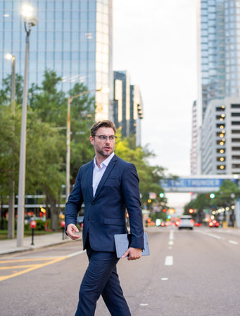 Business man walking in the street in downtown of modern city. Business success of business man outdoor. Handsome successful businessman in elegant suit outdoors.の写真素材
