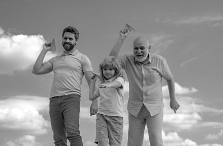 Three generations of men together, portrait of smiling son, father and grandfather with a toy...