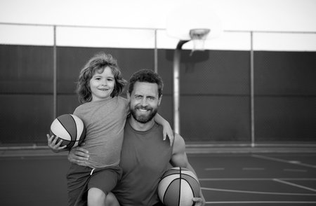 Father and son playing basketball. Family leisure activities concept. Dad and child boy spending time together playing basketball. Sport family.の写真素材