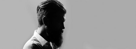 Closeup profile silhouette of bearded man with classic black long beard, bearded gay. Barber barbershop. Mustache men, serious face close up. Templates web banner design. Banner for website.の写真素材