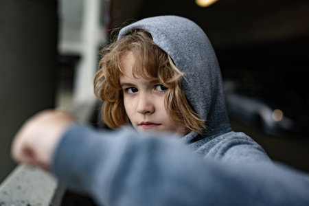 Aggressive anger child. Little kid boy anger on street. Angry little boy showing fist. Portrait of Angry bad kid. Bullied, abuse, Angry children fighting. Aggression little boy. Kids bad behavioral.の写真素材