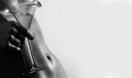 Woman ideal abs with cocktail. Sexy naked girl body. Alcohol drink.の写真素材