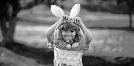 Child boy hunting easter eggs. Child boy with easter eggs and bunny ears in park. Happy Easter.