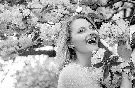 The idea and concept of happy women on International Womens Day. Happy woman with blooming Sakura tree and sunny day.の写真素材