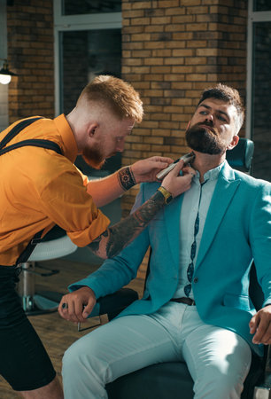 Bearded man or hipster. Ideas about Barbershop and Barber salon. Making haircut look perfect in barber shop. Fine Cuts. Professional hairstylist in barbershop interior.の写真素材