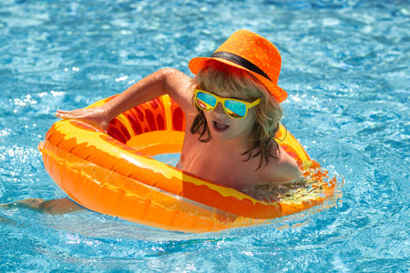 Boy kid swimming and playing in a pool. Child playing in swim pool. Summer vacation concept. Summer...