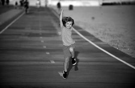 Kid boy outdoors running. Child working out, sport for children, run exercising.の写真素材