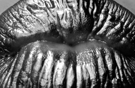 Gold lips kissing macro, golden lipgloss on sexy lips, metallic mouth. Beauty woman kiss close up.