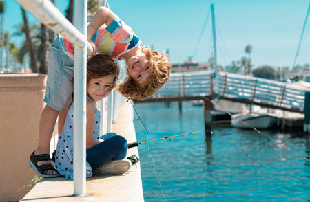 Kids fishing. Couple of children fishing on pier. Child at jetty with rod. Boy and girl with...