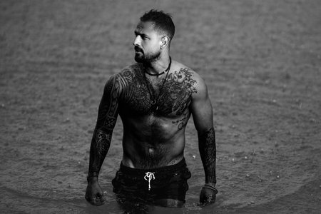 Sexy muscular man standing in summer water. Summer Travel vacation holiday. Relax man, freedom, calm and carefree on summer nature concept. Muscular man in Alps lake. Man freedom lifestyle in nature.の写真素材