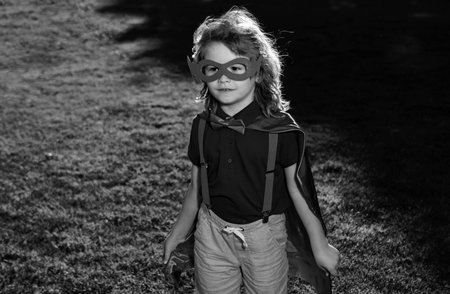 Superhero kid having fun outdoor. Super hero boy over nature. Boy wearing superhero costume and having fun outdoors.の写真素材