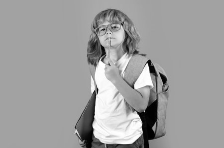 School teenager child with book and copybook. Teenager student, isolated background. Go study. Thinking pensive kids, thoughtful emotions of school child, clever smart funny nerd have idea.の写真素材