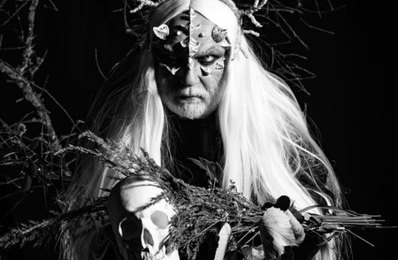 Satan on Hell. Bearded old man dressed like Halloween monster. Man evil with horns. Man with a bull head. Devil horns. Wizard demon man with dragon skin and horns. Demon head isolated on black.の写真素材