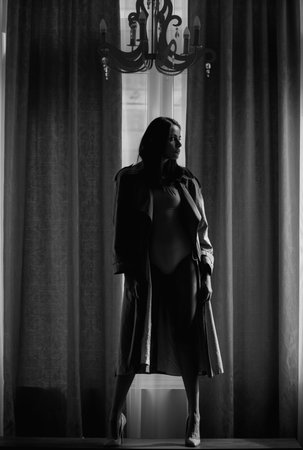 Fashion woman sexy and sensual in luxury apartment posing on window curtains. Seductive sexy lovely attractive young sensual woman with perfect slim body posing on studio background.の写真素材
