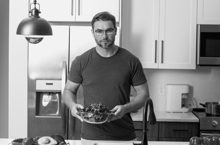 Vegetables diet. Young woman eating healthy food, dieting. Guy eating vegetable diet salad in studio. Vegan salad. Male on diet. Dieting concept. Healthy lifestyle. Diet for weight loss.の写真素材