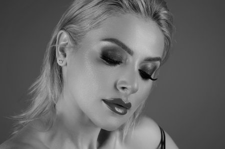 Facial treatment. Beauty woman with fashion eyes make up, red lipstick on plump lips, close up face. Young woman with clean fresh skin. Beauty portrait of young women with beautiful face.の写真素材