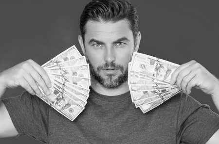 Successful business man counting money. Handsome middle age man holding bunch of 100 dollar banknotes. Guy holding money cash. Profit and financial success. Rich man with dollar cash.の写真素材