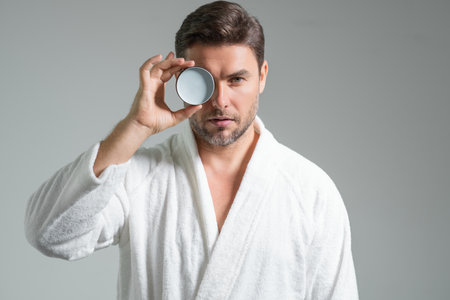 Man with cosmetic cream. Male spa model applying skin care cream product. Morning skincare cream, lifting and anti-aging wrinkle effect. Skin care. Man with perfect soft skin. Beauty cosmetic product.の写真素材