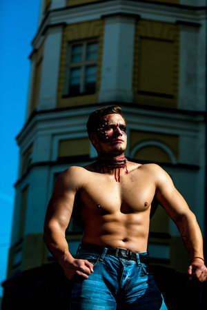 Halloween. Muscular man with face paint and fake blood. Scary face man with horror make up.の写真素材