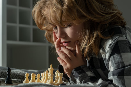 Chess game with children at home. Clever child thinking about chess. Portrait of clever kid with chessboard. Boy play chess.の写真素材