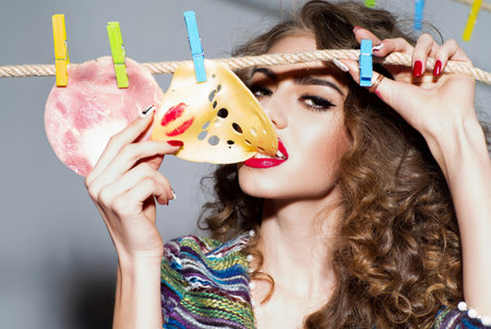 Woman holding a slice of cheese. Girl with a slice of cheese. Woman eating cheese. Delicious piece of cheese or sausage.の写真素材