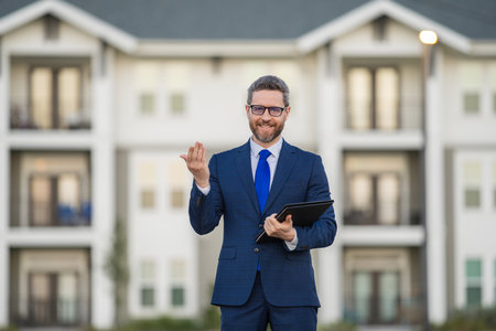 Financial Real estate agent business man in suit hold holder clipboards outside. Hispanic Businessman. Business Man broker or real estate agent. Business man in suit outdoor. Real estate business man.の写真素材