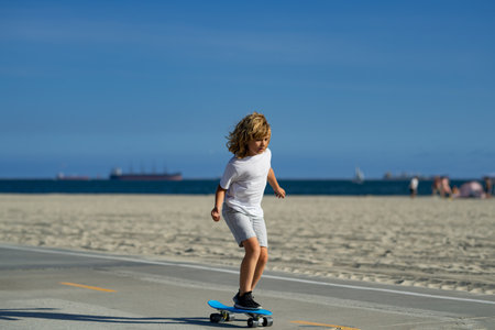 Child skateboarding at park in the city. Kid boy enjoy and having fun outdoor lifestyle. Child practicing extreme sport longboard skating on summer road. Concept of activity and happy childhood.の写真素材