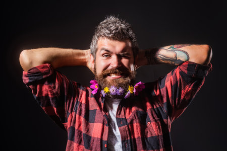 A bearded man with a decorated beard for the Spring holiday. Flower in the beard. Male prickly...