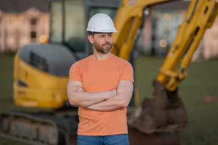 Construction build man with excavator at industrial site. Worker in helmet with bulldozer. Engineer...